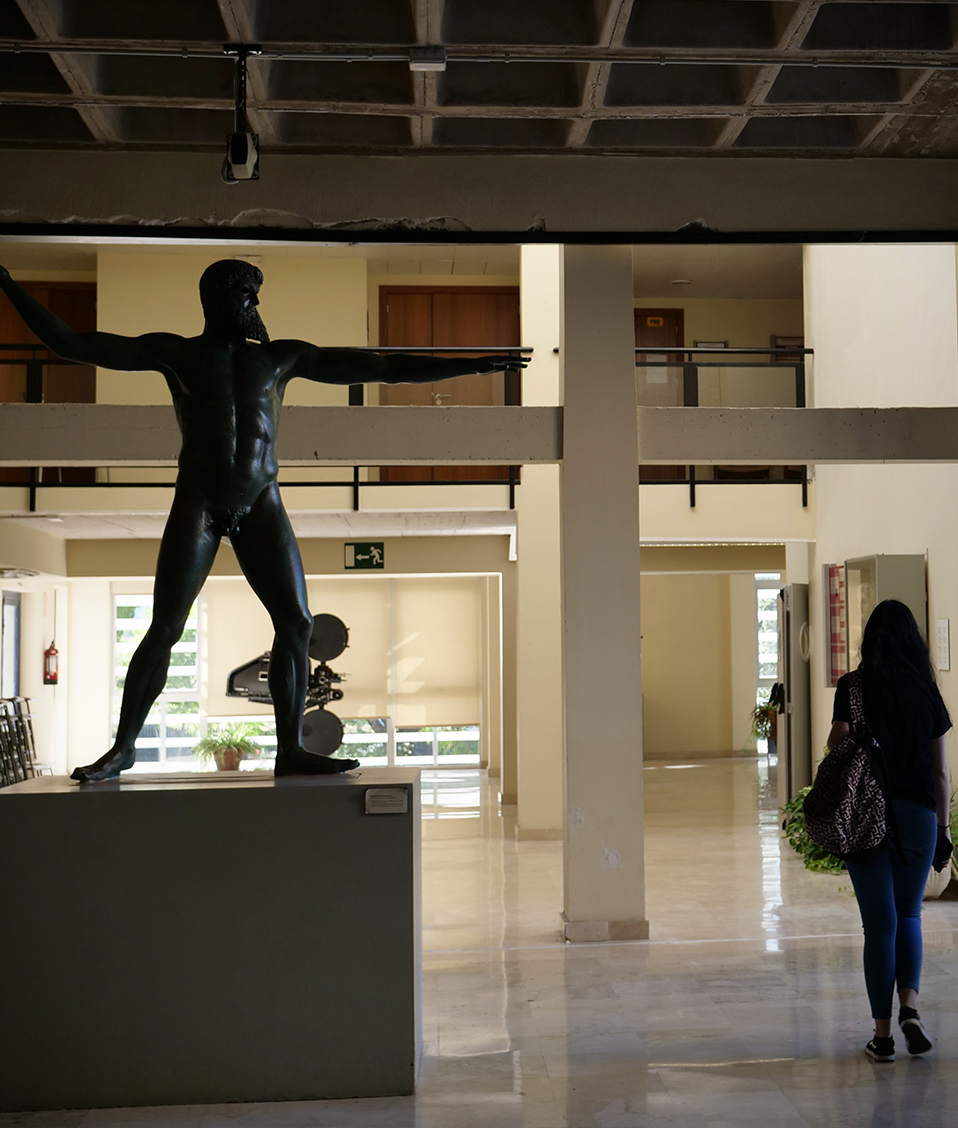 Estatua de un personaje mitológico (Zeus o Poseidón) con los brazos extendidos en la Facultad de Filosofía y Letras